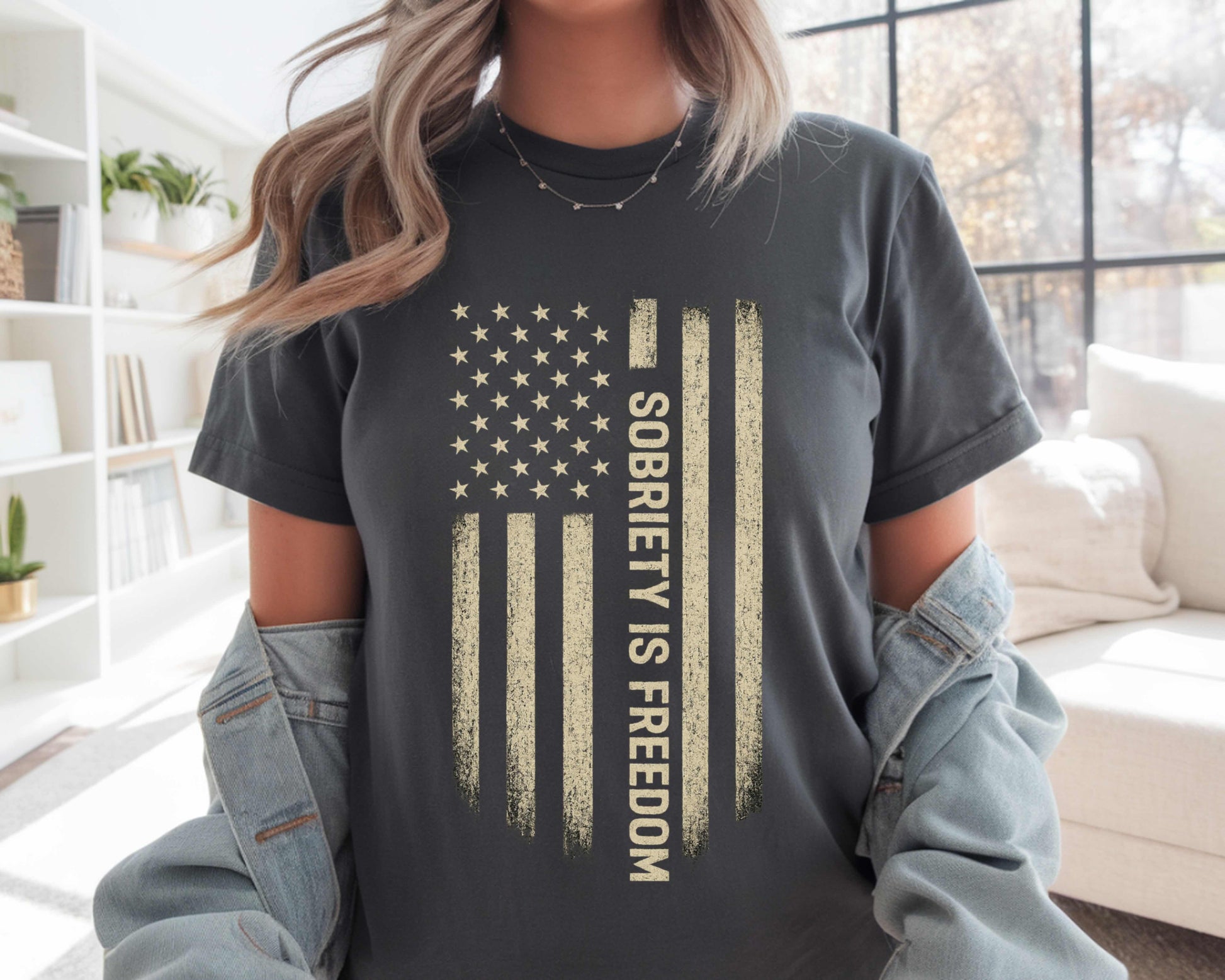 Person wearing a t-shirt with 'Sobriety is Freedom' design in a living room setting