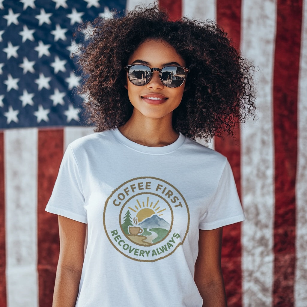 Person wearing a 'Coffee First, Recovery Always' t-shirt in front of an American flag.