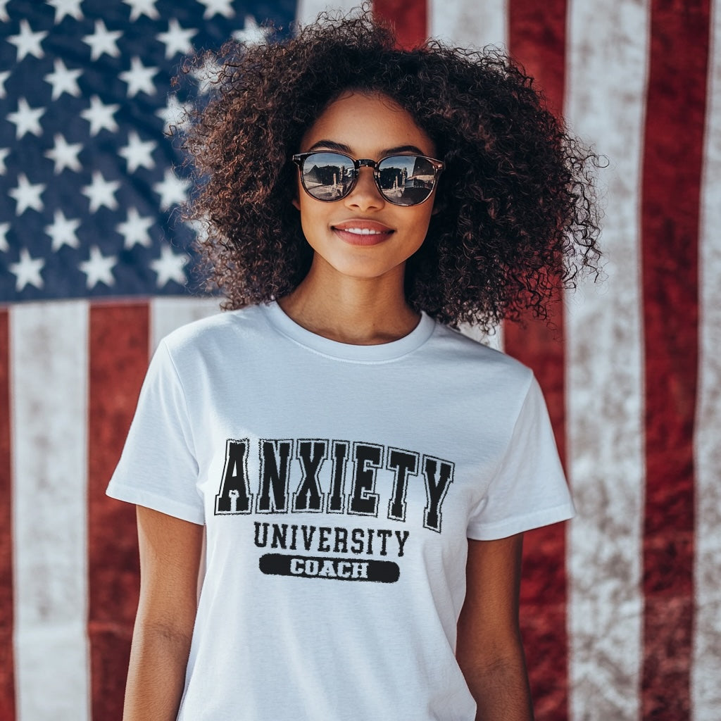 Person wearing a t-shirt with 'Anxiety University Coach' text in front of an American flag.