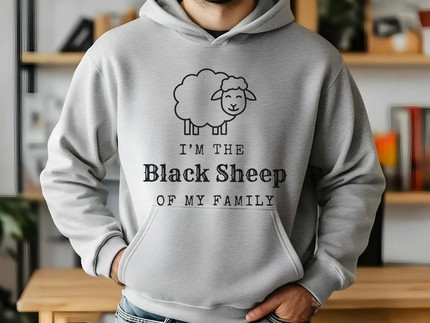 Person wearing a gray hoodie with 'I'm the Black Sheep of My Family' design in a casual setting.
