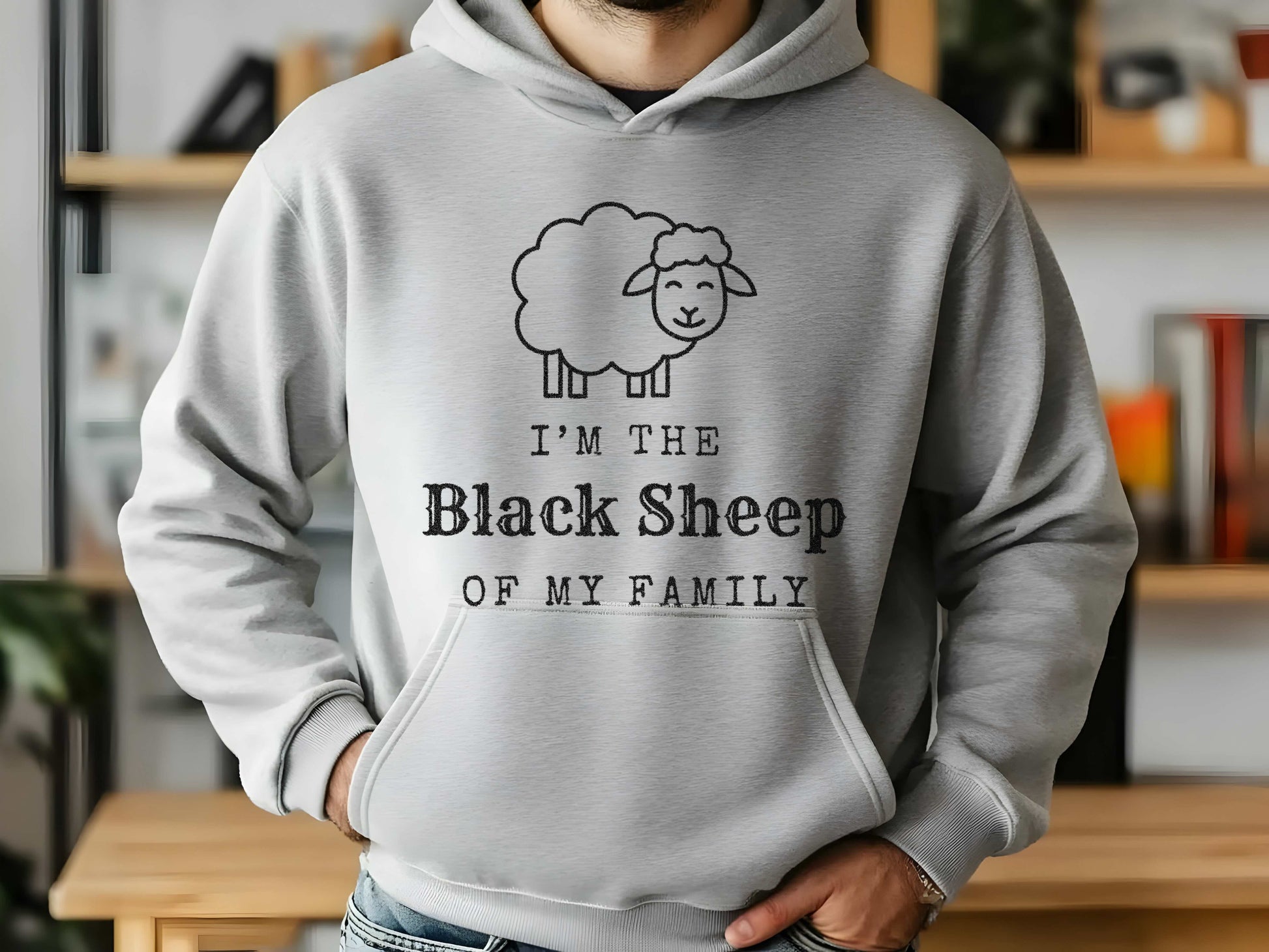 Person wearing a gray hoodie with 'I'm the Black Sheep of My Family' design in a casual setting.
