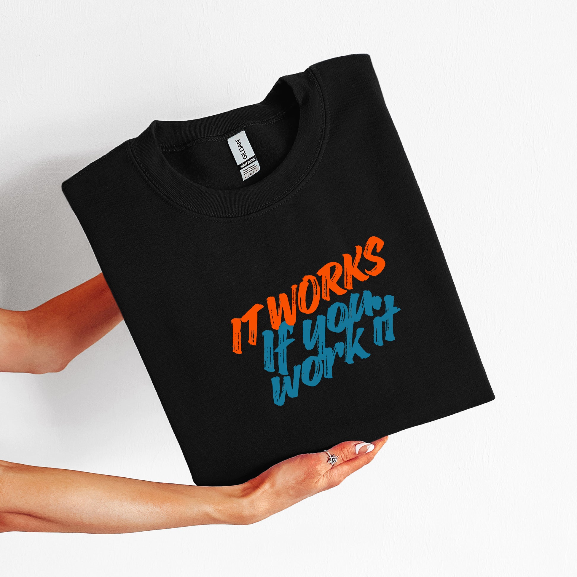 Black t-shirt with colorful text held by a person on a white background