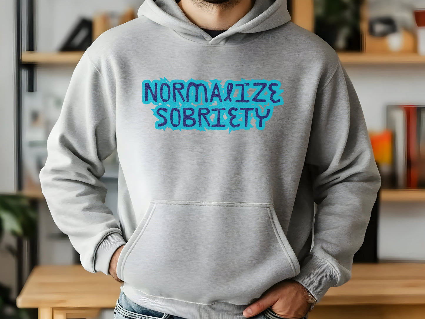 Person wearing a gray hoodie with 'NORMALIZE SOBRIETY' text in blue.