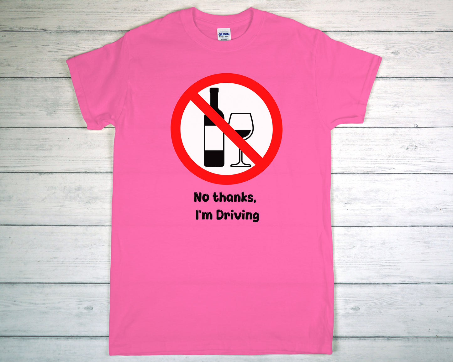 Pink t-shirt with a no drinking while driving symbol on a wooden background