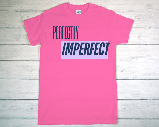 Pink t-shirt with 'Perfectly Imperfect' text on a wooden surface