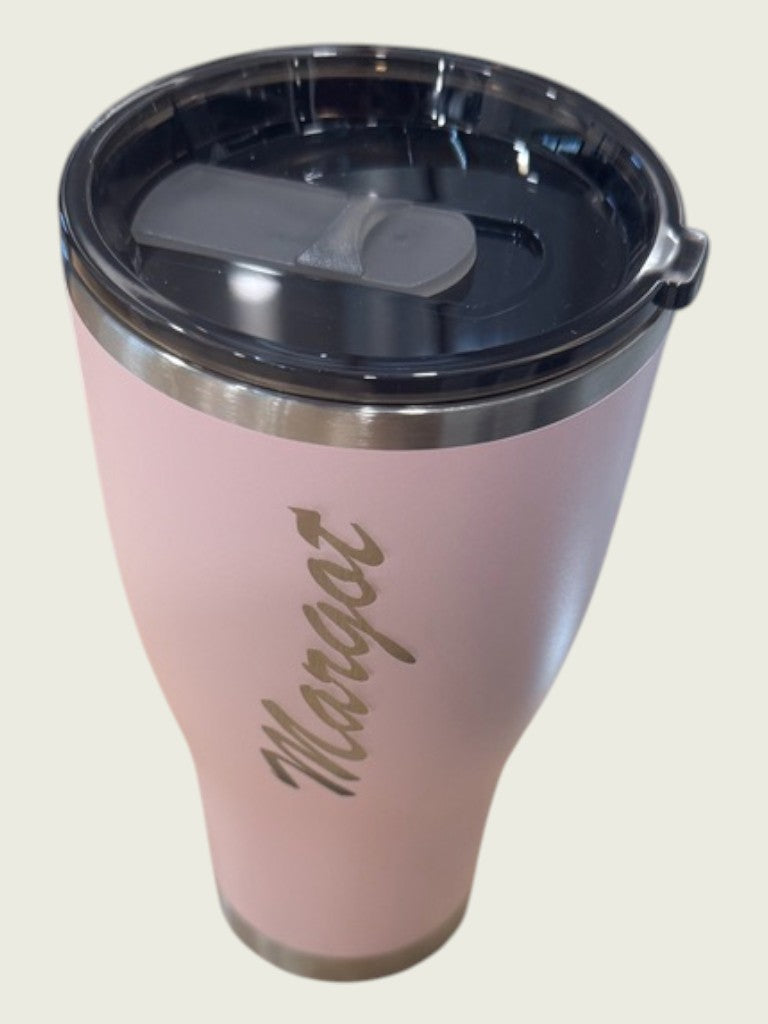 Pink insulated tumbler with a black lid on a light beige background