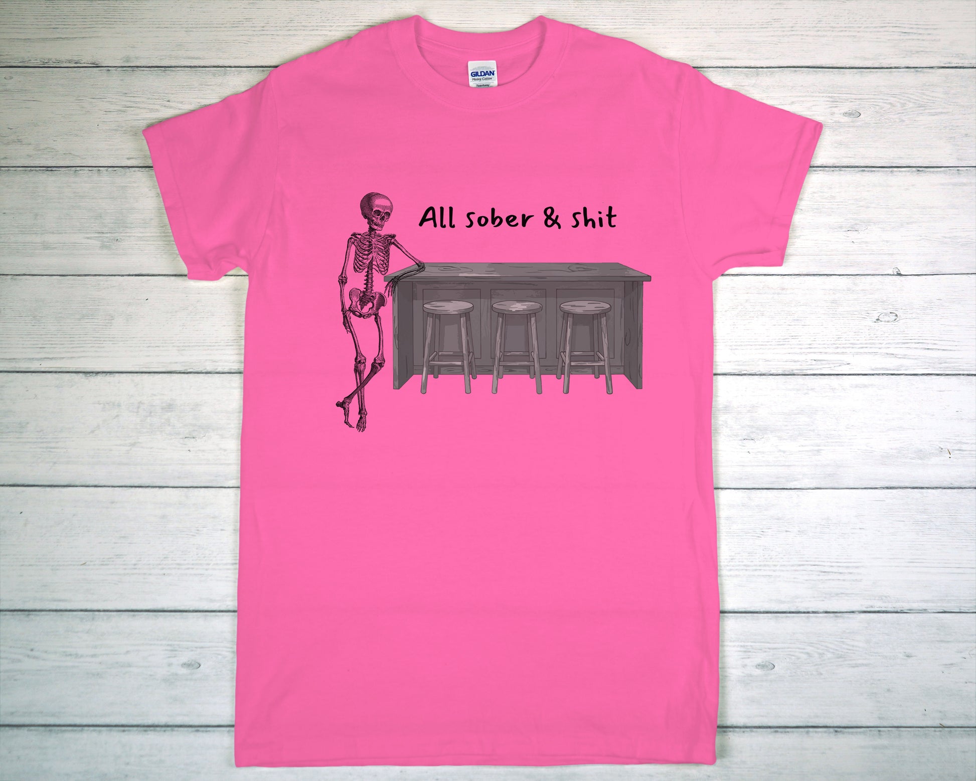 Pink t-shirt with skeleton and bar graphic on a wooden background