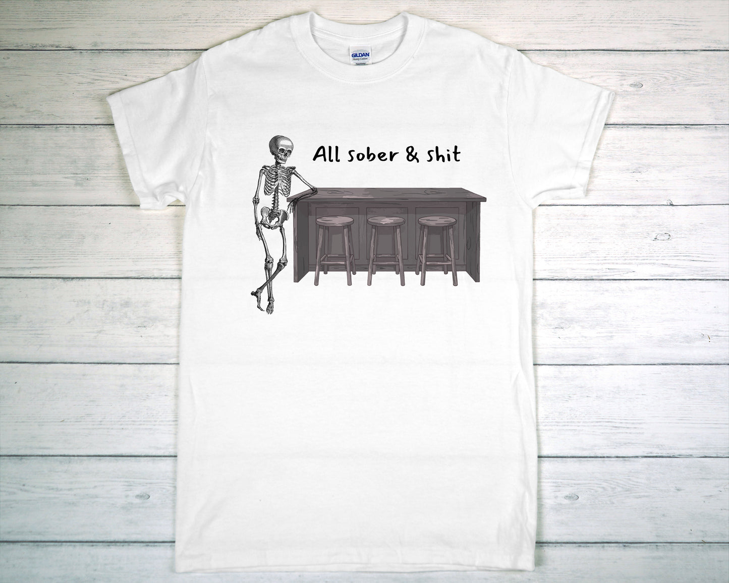 White t-shirt with a skeleton graphic and text on a wooden background