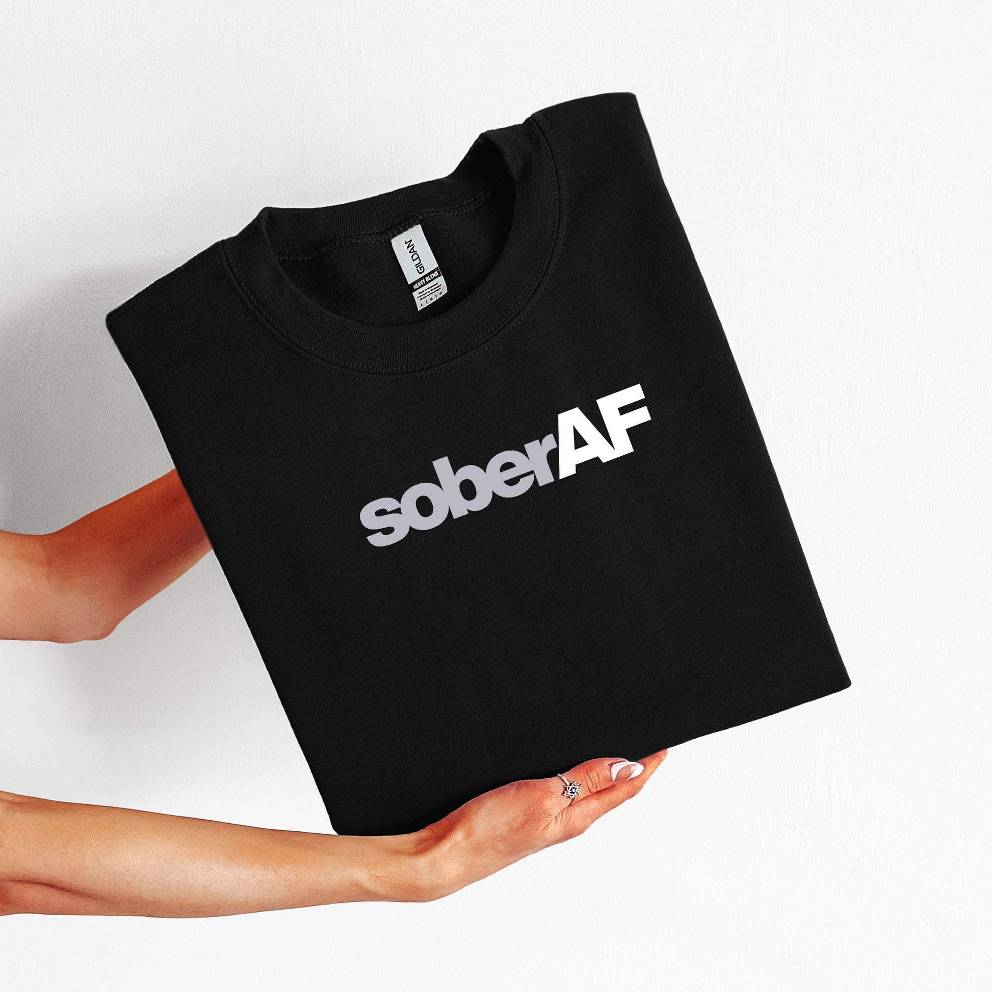 Black t-shirt with 'soberAF' text held by a person on a white background