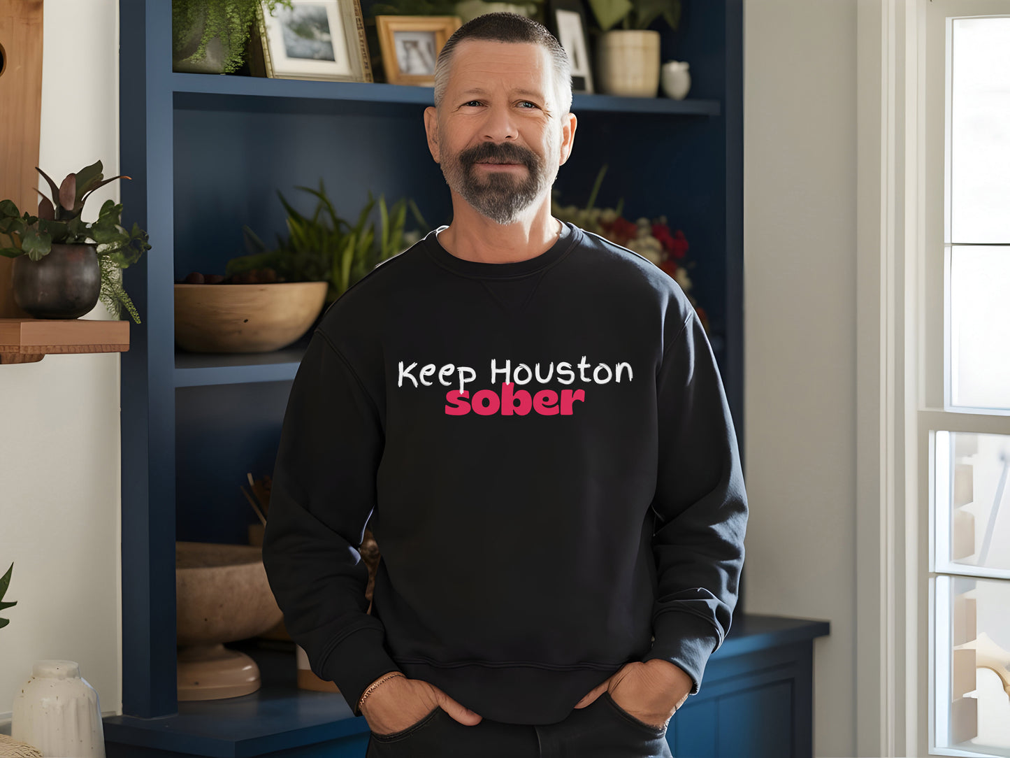 Man wearing a black sweatshirt with 'keep Houston sober' text in a home setting