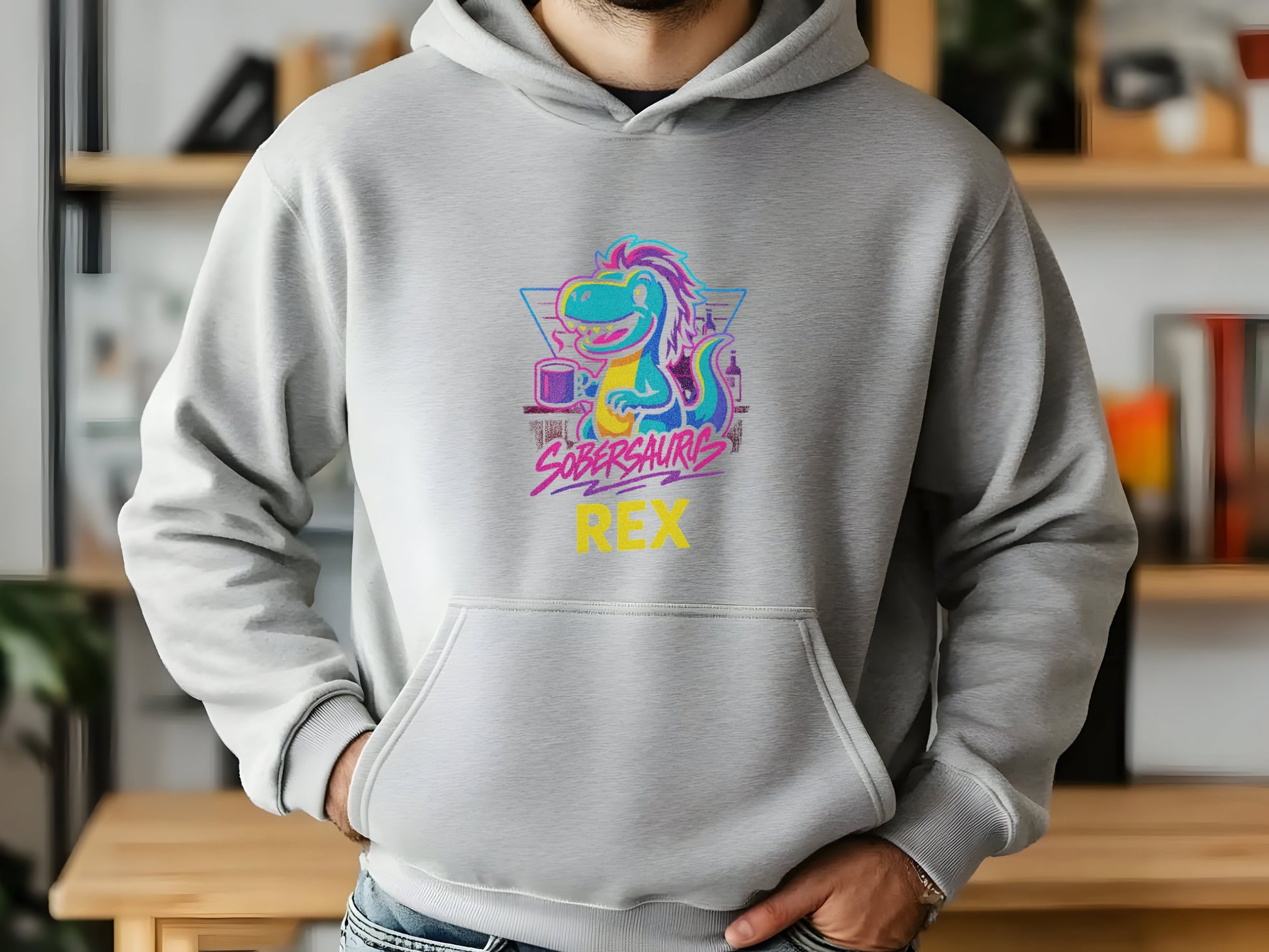 Person wearing a gray hoodie with a colorful dinosaur graphic and "Sobersaurus Rex" in an indoor setting.